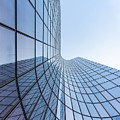 Blue curved glass skyscraper facade against sky